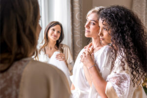 De jeunes femmes se tiennent ensemble le jour de mariage de l'une d'entre elles. Elles portent toutes un kimono en soie et dentelle de Calais Aime Couture